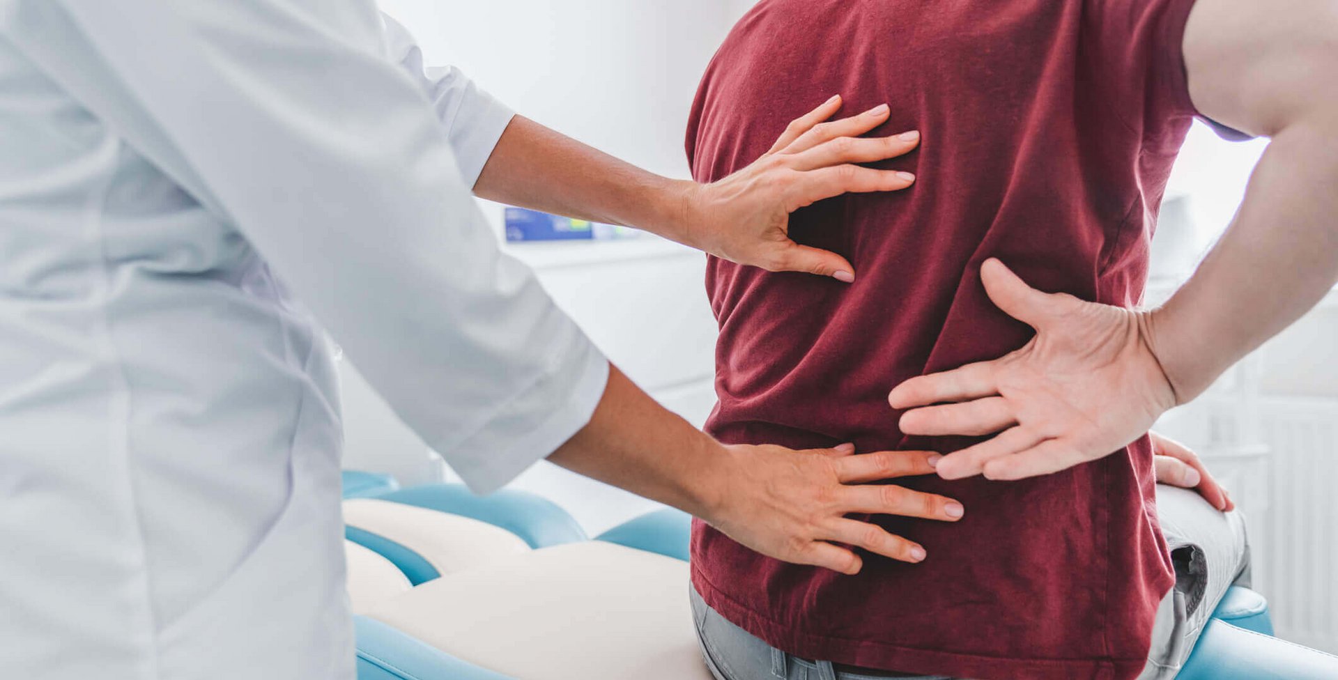 Ein Arzt führt mit einer Patientin ein Beratungsgespräch in seinem Behandlungszimmer.
